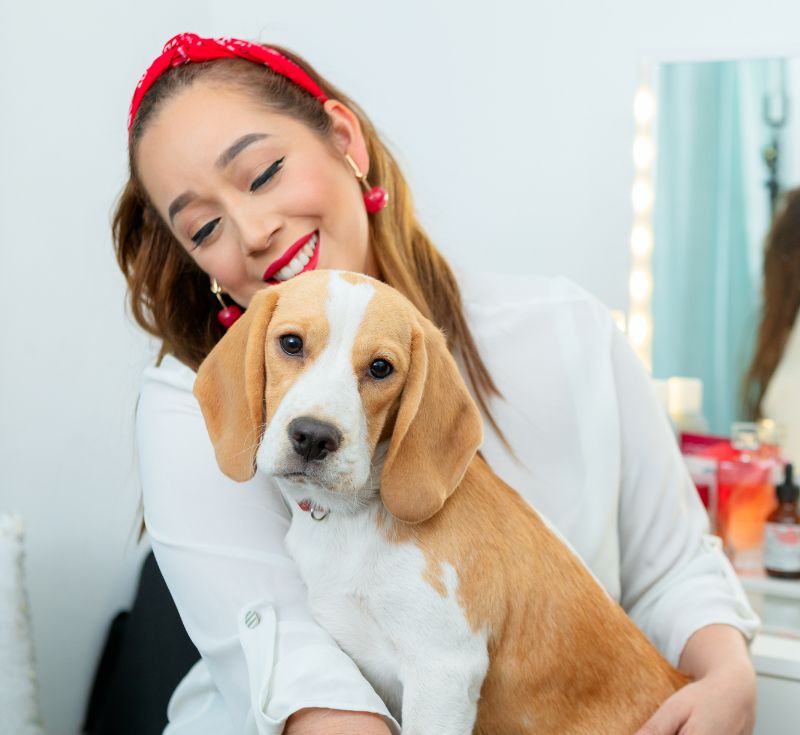 Woman smiling while holding a beagle puppy. Woman smiling while holding a beagle puppy.
